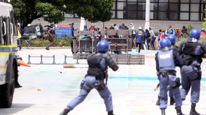 Students and police clash at NMU (then NMMU) during #FeesMustFall protests in October 2016.