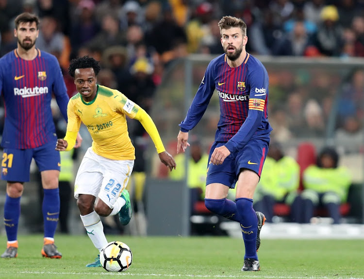 Gerald Pique of Barcelona challenged by Percy Tau of Mamelodi Sundowns during the 2018 Mandela Centenary Cup Friendly match between Mamelodi Sundowns and Barcelona at FNB Stadium, Johannesburg on 16 May 2018.