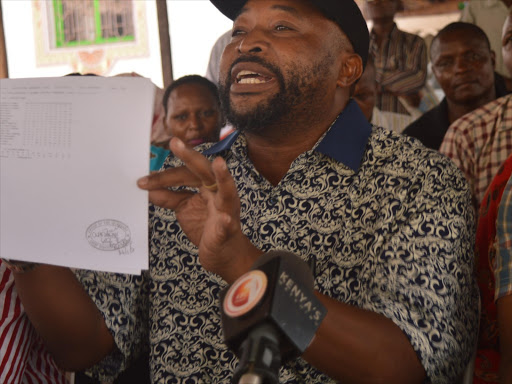 Jubilee politician Ananiah Mwaboza displays a copy of Mombasa Governor Hassan Joho's KCSE certificate at Jawambe hotel in the county, March 26, 2017. /JOHN CHESOLI