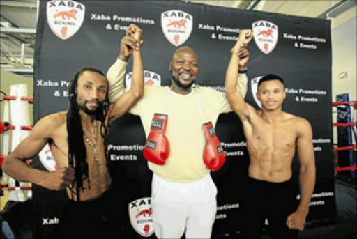 Xaba Promotions and Events boss Ayanda Matiti is flanked by Bongani Mahlangu, left, and Ludumo Lamati ahead of their title fight Picture: SINO MAJANGAZA