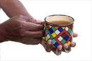 An African woman holding a mug decorated in Xhosa  style beads. File photo.