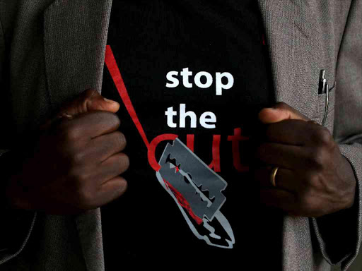 A man shows the logo of a T-shirt that reads 'Stop the Cut', referring to Female Genital Mutilation (FGM), during a social event advocating against harmful practices at Imbirikani Girls High School, April 21, 2016. /REUTERS