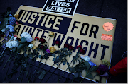 Flowers are laid on a sign as protesters rally outside the Brooklyn Center Police Department, days after Daunte Wright was shot and killed by a police officer, in Brooklyn Center, Minnesota, US on April 13 2021.