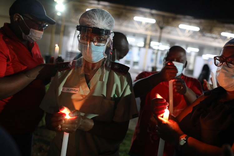 Healthcare workers light candles on December 31 2020 at Charlotte Maxeke Hospital in Johannesburg.