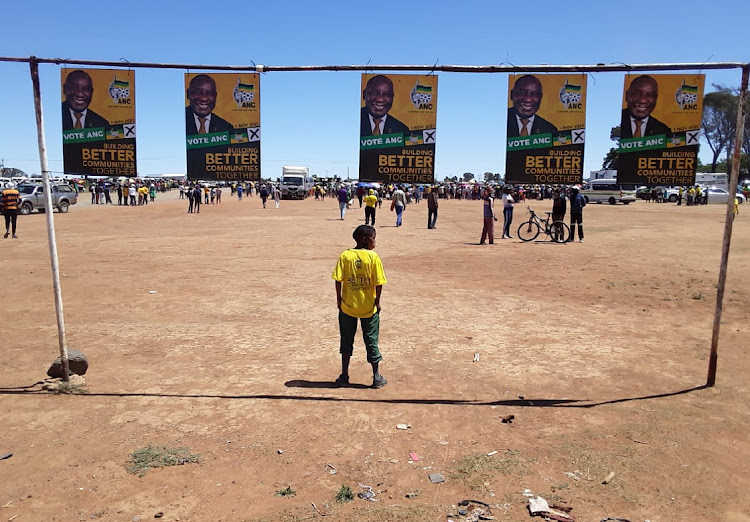 A boy wearing an ANC T-shirt stands underneath posters bearing the face of party president Cyril Ramaphosa during a campaign rally in Mangaung. Picture: Ziphozonke Lushaba