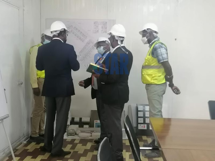 Principal Secretary for Housing and Urban Development Charles Hinga consulting with constructors at Pangani on Septmber 27, 2021.