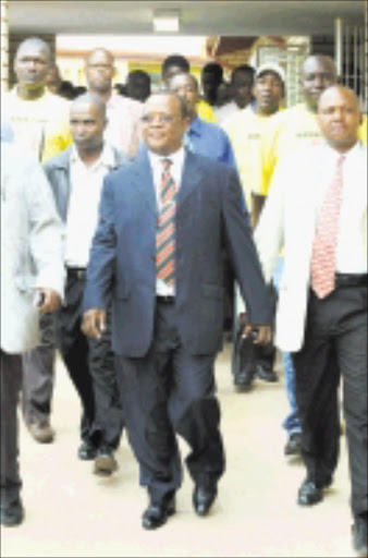 BACK TO COURT: Chief Nyalala Pilane and his bodyguards arrive at the Mogwase regional court, North West, on Friday. 15/03/09. Pic. Peter Mogaki. © Sowetan.