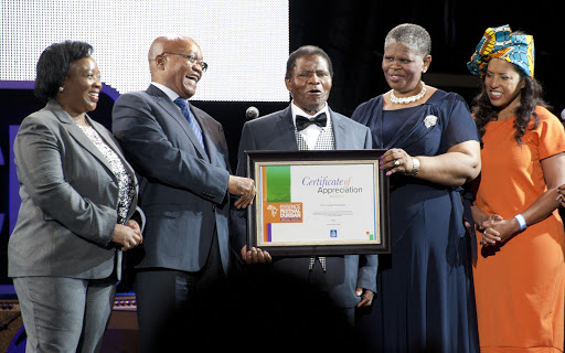 President Jacob Zuma and Ethekwini mayor Zandile Gumede honour Ladysmith Black Mambazo’s retired lead vocalist; Joseph Shabalala with a certificate of appreciation during the Essence Festival All Star music concert in November 2016.