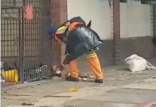 A municipal worker was filmed picking up rubbish and throwing it into a resident's garden.