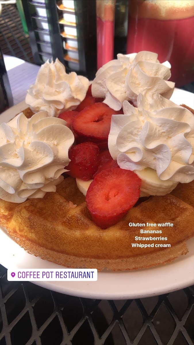 Gluten free waffle with strawberries, bananas, and whipped cream.