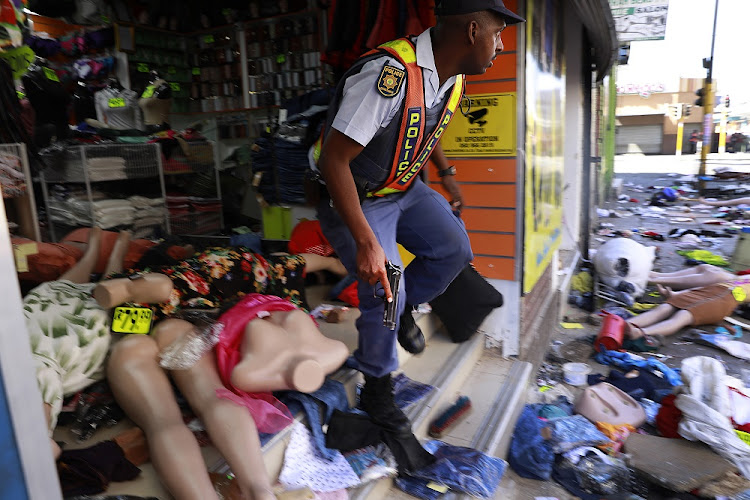 A policeman moments after a foreign-owned shop was looted recently in the Johannesburg CBD.