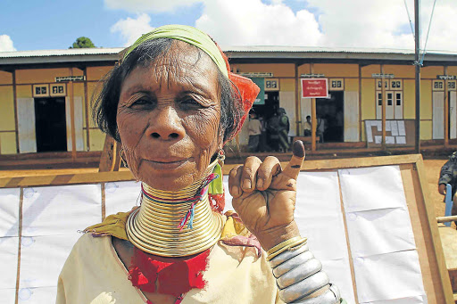 HISTORICAL VOTE: A Kayan woman, from one of Myanmar’s ethnic minority groups, shows her ink-stained finger after she voted yesterday, in front of a polling station in Panpet village, Demoso township, Kayah state Picture: REUTERS