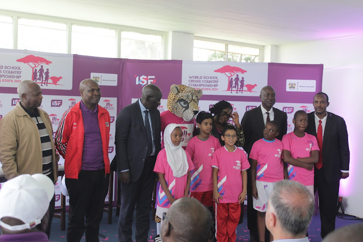 Athletics Kenya President Jackson Tuwei (L), KSSSA chairman Kipchumba Mayo, Education PS Belio Kipsang, ISF mascot, ISF delegate Joseph Olabisi, Secretary Admin Ministry of Sports Evans Achoka and Local Organising Committee chair Hassan Duale with kids during the launch of the School World Cross Country Championships at the Ngong Racecourse, Nairobi, on March 14