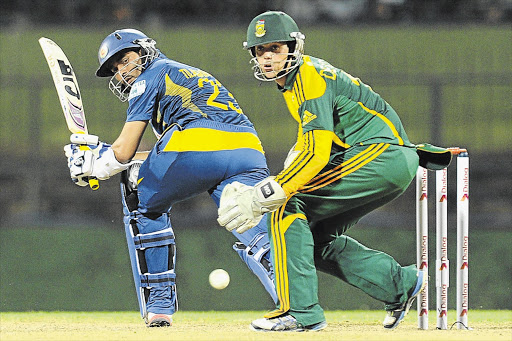 Sri Lankan batsman Tillakaratne Dilshan plays a shot watched by South African wicketkeeper Quinton de Kock during the fourth ODI at the Pallekele International Cricket Stadium yesterday. Sri Lanka thrashed the Proteas by eight wickets