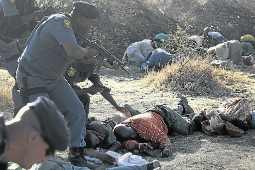 TRAGIC AFTERMATH: Police check on casualties after firing on striking Lonmin mine workers. Locals believe muti prevented many more from being killed