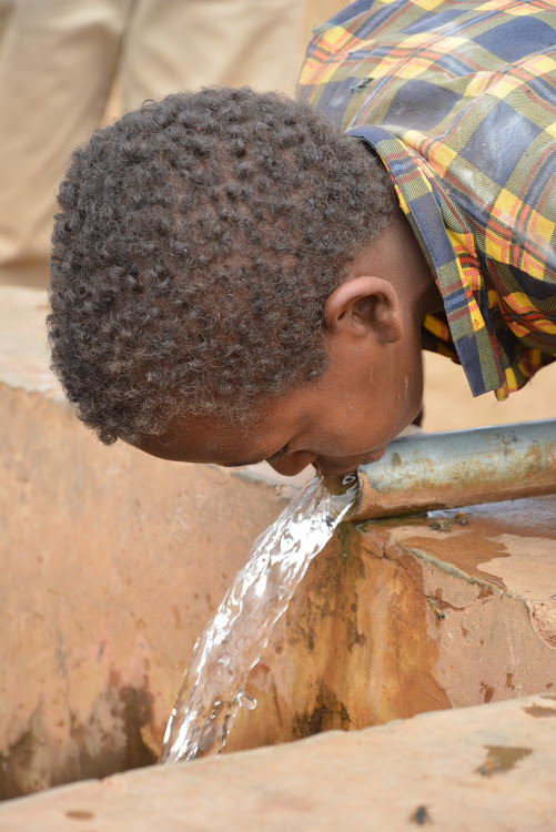 A boy drinks water at a cattle dip in Moyale, Marsabit county.