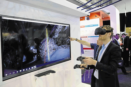 DIG IT: A delegate experiences a virtual reality headset at the annual Mining Indaba in Cape Town.