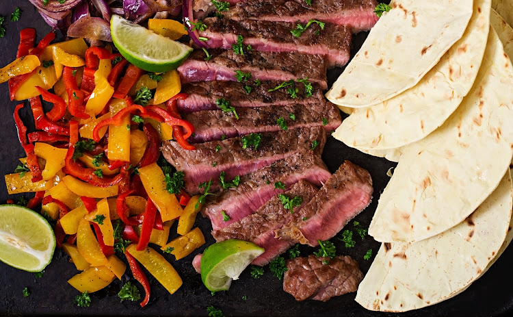 Mexican citrus and tequila steak (carne asada) served with a red-and-yellow pepper salad.