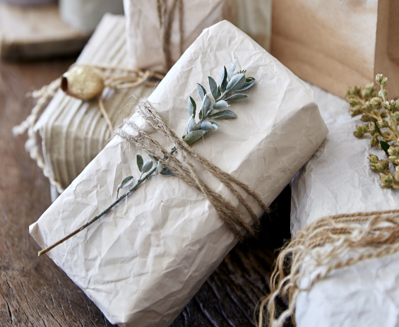 Layered and textured gift wrapping with natural elements.
