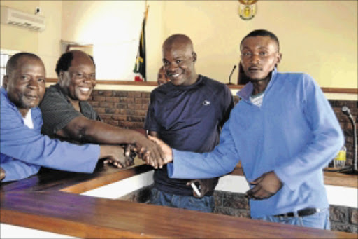 OLIVE BRANCH: Thohoyandou businessman Goddard Mugwena, second left, and his younger brother Amos, shake hands with the men hired to kill him, Moses Ntlenana, third from left, and Vincent Phakula after they were convicted PHOTO: BENSON NTLEMO