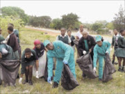 DIRT REMOVAL: Nkomazi mayor, Johan Mavuso, wearing blue gloves, picks up refuse with community members. Pic: Riot Hlatshwayo. 26/10/2009. © Sowetan.