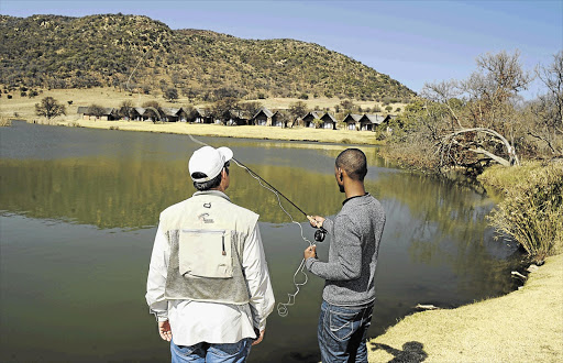 WRIST ACTION: Wayne Sinclair directs Yolisa Mkele in the art of fly fishing as war