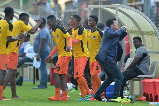 Polokwane City coach Luc Eymael (R) celebrates with his players on the bench during the Absa Premiership match against Highlands Park at Makhulong Stadium on February 12, 2017 in Johannesburg, South Africa.