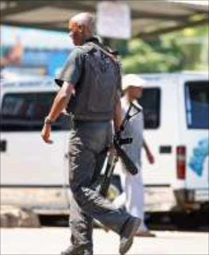 TENSE TIME: A guard monitors the situation at the height of violence at the Stanger main taxi rank in KwaZulu-Natal. Pic. mandla Mkhize. © Sowetan.