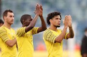 Bafana Bafana players Bradley Grobler (L), Maphosa Modiba (C) and Keagan Dolly (R) applaud the fans after their 2019 Africa Cup of Nations qualifying match against Libya at the Moses Mabhida Stadium in Durban on September 8 2018.