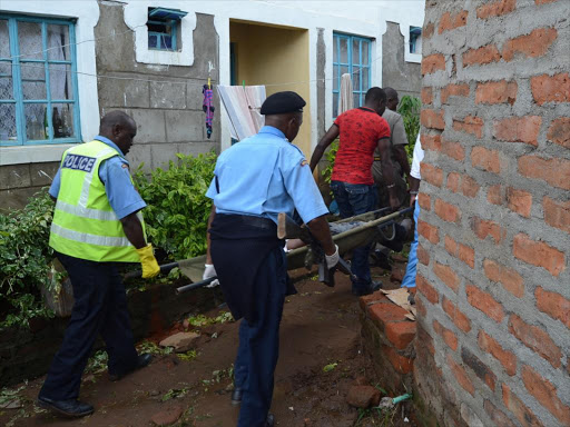 Police officers carry the body of a Kenya Defence Forces officer who killed his girlfriend and then shot himself after she allegedly broke up with him in Kitui town, April 25, 2016. Photo/MUSEMBI NZENGU