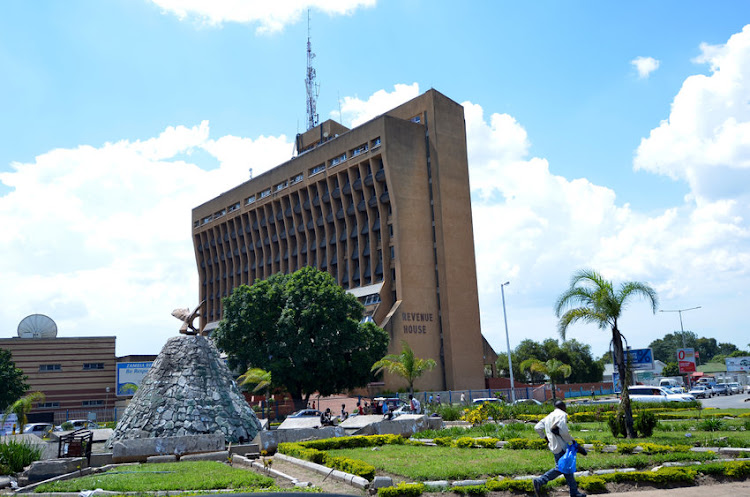 A man walks past Square Revenue House in Lusaka, Zambia. Zambia hopes to agree on key conditions for restructuring $3bn of its bonds no later than the first quarter of 2024, secretary to the Treasury Felix Nkulukusa said File photo:123RF/DJEMBE