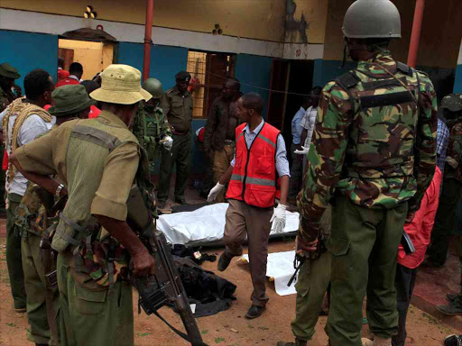 Police officers stand by dead bodies after an attack by Islamist militants from the Somali group al Shabaab in Mandera, Kenya, October 6, 2016. /REUTERS