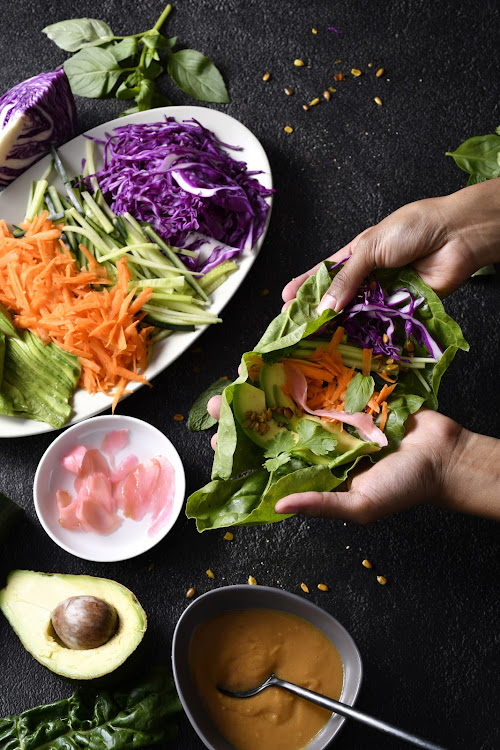 Rainbow salad wraps with peanut sauce.