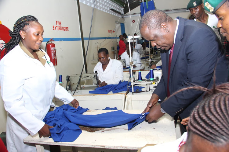 Interior CS Fred Matiang'i looks at the newly knitted police uniform at NYS.