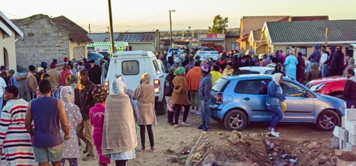 Police, emergency services, parents and onlookers have filled the streets near Enyobeni Tavern in Scenery Park, where at least 22 people have been killed.