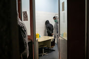 Police officers in protective suits detain a migrant who is suspected of having Covid-19 at the infection clinic in Belgrade, Serbia, on March 17 2020. 