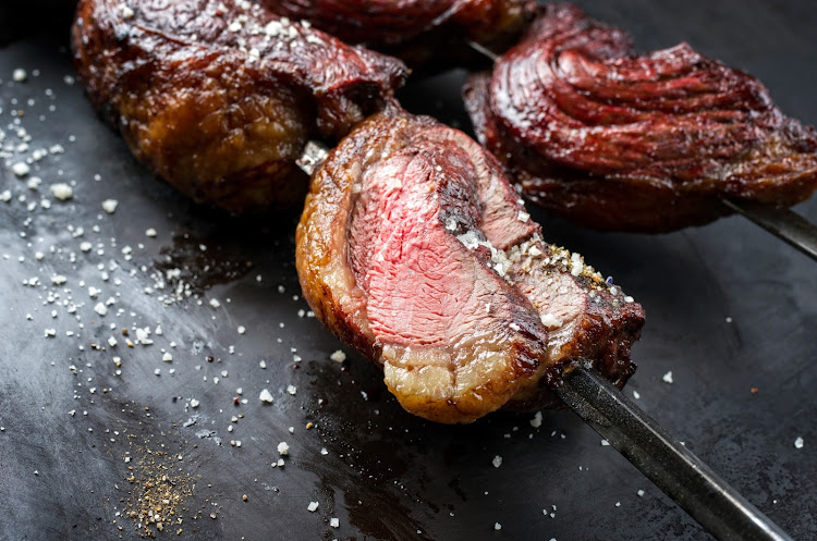 Brazil's picanha steak is threaded onto metal kebab sticks, with the fat side folded around the meat and cooked over a flame.