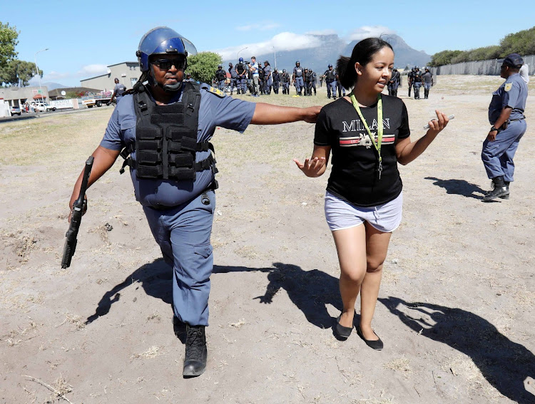 A female student at the Western Cape College of Nursing in Athlone is arrested by a member of the public order police.
