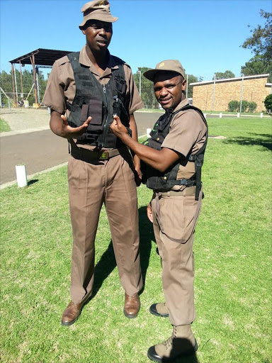 Lungisani Ndlela (L) posing with a correctional services colleague.