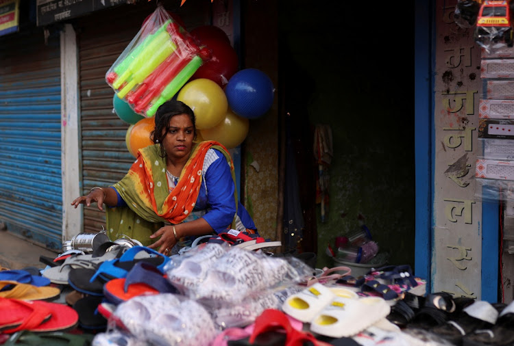 Nayantara Gupta, 28, arranges slippers outside her shop in a slum in Bhopal, India on February 7 2024.