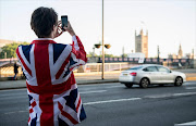 A vote LEAVE supporter takes a photo of Parliament from outside Vote Leave HQ, Westminster Tower on June 24, 2016 in London, England. The United Kingdom has gone to the polls to decide whether or not the country wishes to remain within the European Union. After a hard fought campaign from both REMAIN and LEAVE the vote is awaiting a final declaration and the United Kingdom is projected to have voted to LEAVE the European Union. Picture Credit: Getty Images/Chris J Ratcliffe