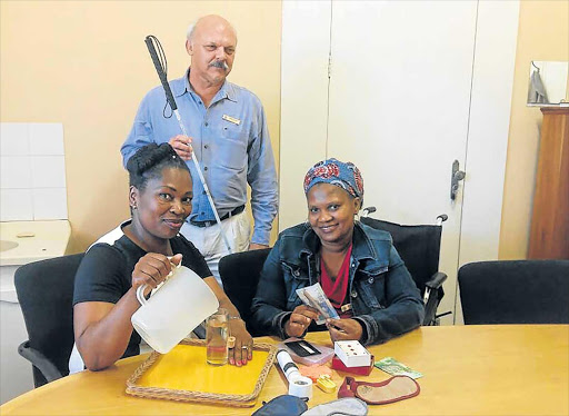 HELPFUL HANDS: Rehab employees Thandeka Saleni, left, and Phumza Selwadda are training to become mobility and orientation practitioners for the blind. Rehab director Rueben Puchert, who is himself blind, says there is an urgent need to help the region’s blind and partially-sighted people Picture: BARBARA HOLLANDS