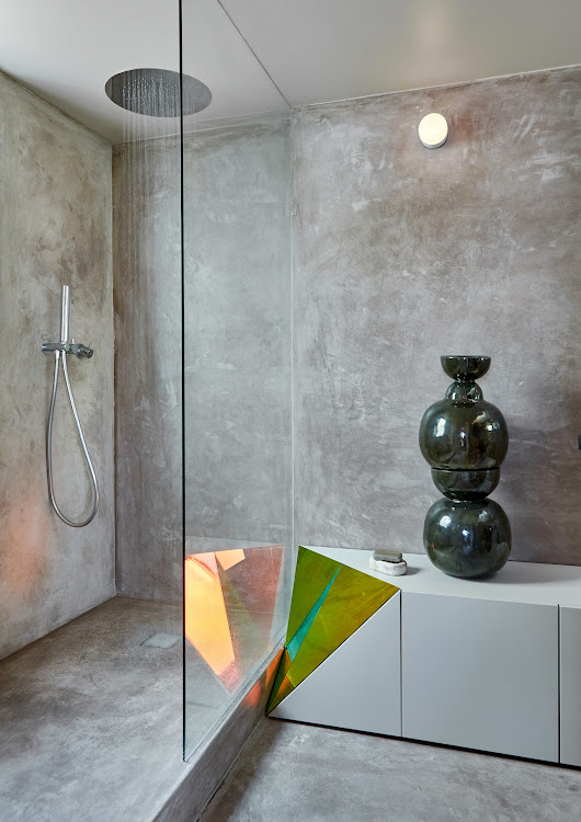 In the bathroom on the main floor of the apartment, the prismatic theme is continued in the built-in storage. The ceramic sculpture is by Kluk and the shower rose and tapware are from ASM Taps.