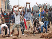 Supporters of opposition leader Raila Odinga hold up boulders in front of a barricade in Kawangware slum in Nairobi, Kenya.   REUTERS/Goran Tomasevic