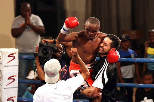 UPLIFTING: Malcolm Klassen and his trainer Errol Saffy celebrate after he scored a stoppage victory over Xolani Mcotheli Picture: ALAN EASON