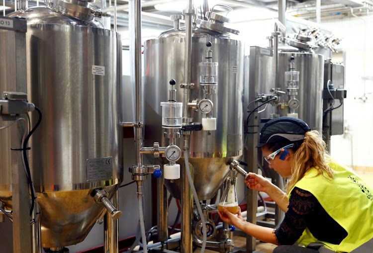 A worker checks beer quality at an Anheuser-Busch InBev brewery in Leuven, Belgium. Picture: FRANCOISE LENOIR/REUTERS