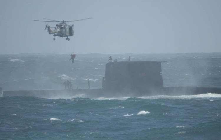 A Super Lynx helicopter hovers above the submarine during the training exercise off Kommetjie. File photo.