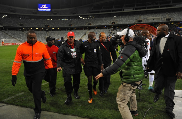 Referee Cedric Muvhali is escorted off the field during the Absa Premiership match between Cape Town City FC and Polokwane City at Cape Town Stadium on September 22, 2017 in Cape Town, South Africa.