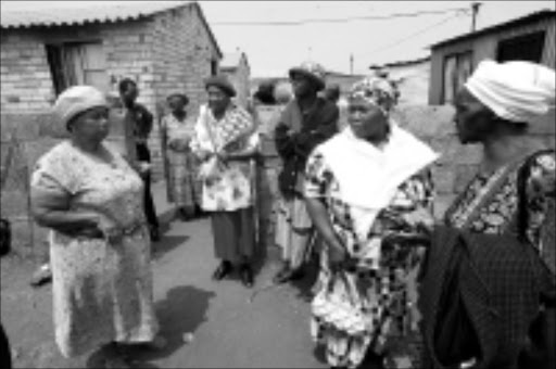 STALLED FUNERAL: Mourners gather at Alfred Lebakeng's home in Chiawelo but were disappointed to hear that his funeral could not take place.Pic. Veli Nhlapo. 07/101/2008. © Sowetan.