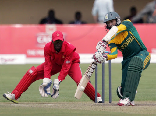 South African batsman Hashim Amla plays a shot as wicket keeper Richmond Mutumbami looks on during the 1st ODI match between Zimbabwe and South Africa at Queens Sports Club on August 17, 2014 in Bulawayo, Zimbabwe.